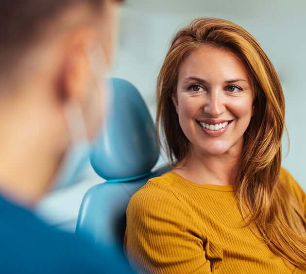 woman listening and smiling at dentist