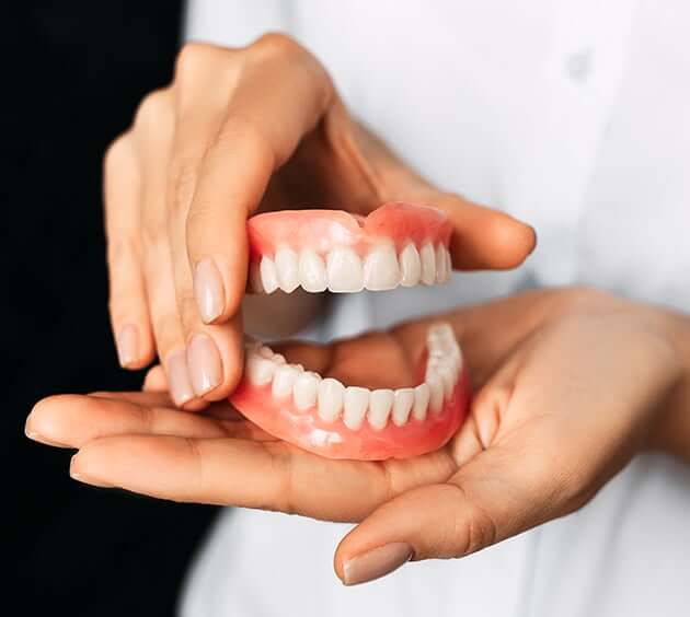 person holding dentures