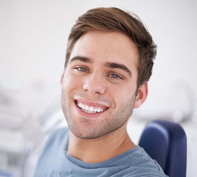 man smiling while at the dentist
