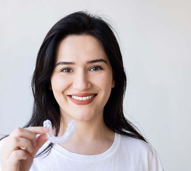 smiling woman holding nightguard