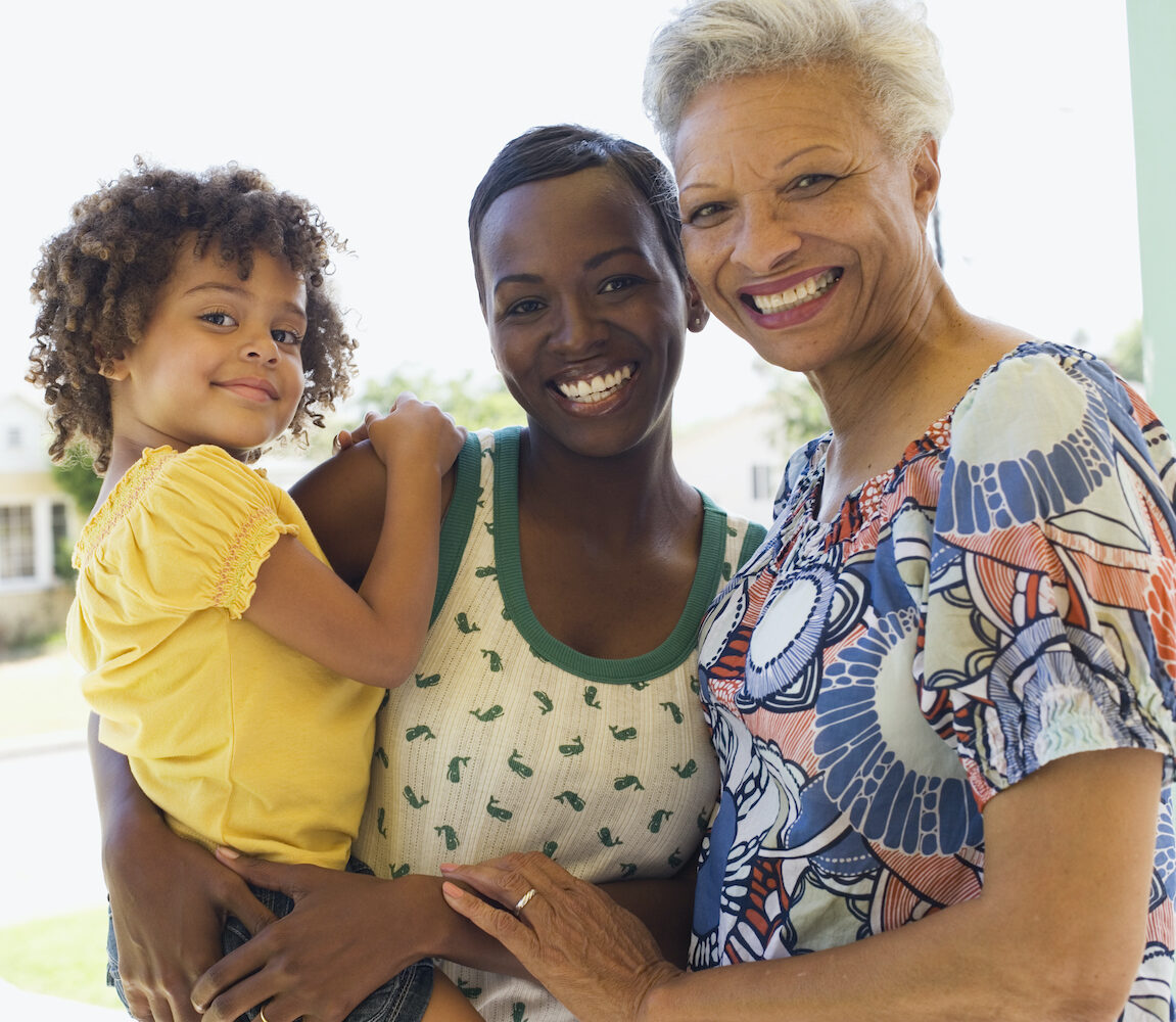 A grandma, mom, and daughter smile together