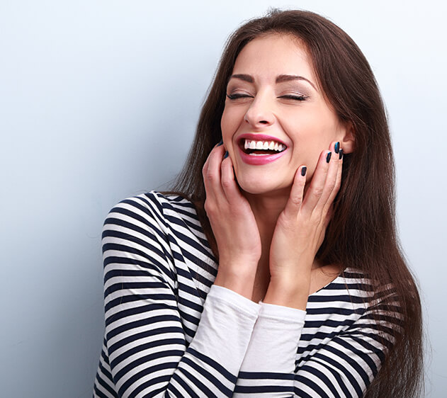 smiling woman holding her face in her hands