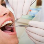 oral cancer screening on female patient in dental chair to see the symptoms of oral cancer