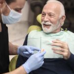 man in dental chair getting his new dentures getting used to new dentures