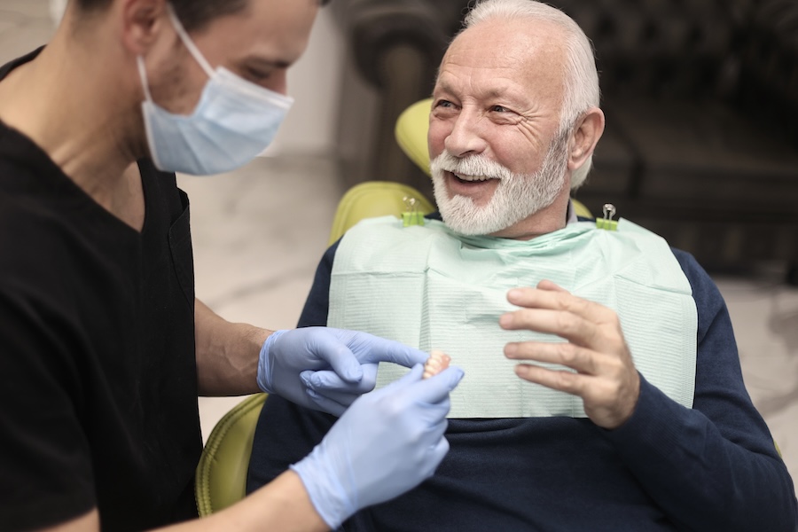 man in dental chair getting his new dentures getting used to new dentures