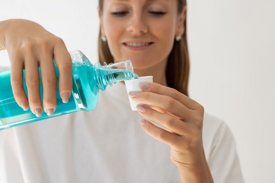 woman using mouthwash, is mouthwash necessary